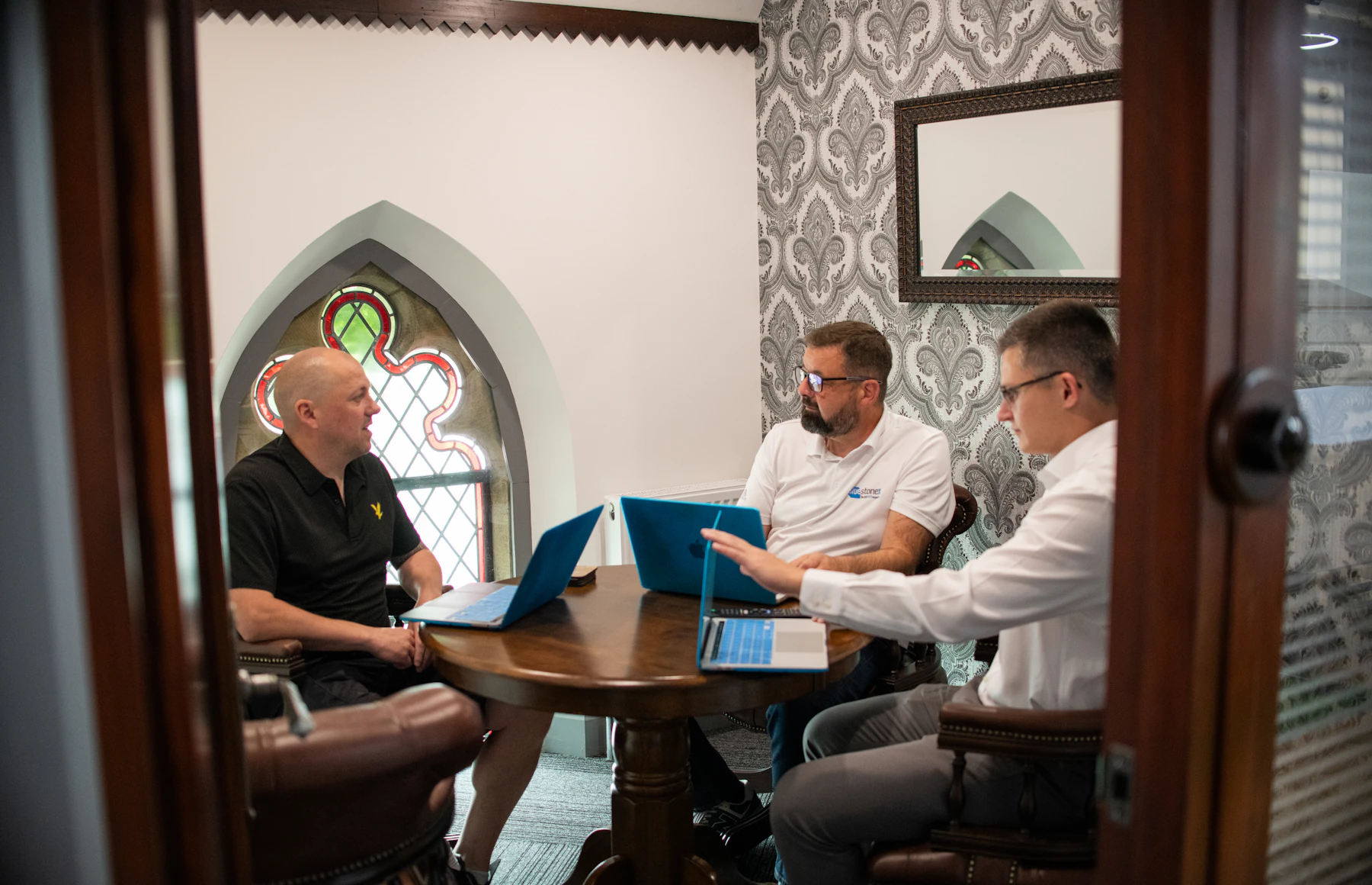 Senior team reviewing website strategy and project priorities around laptops